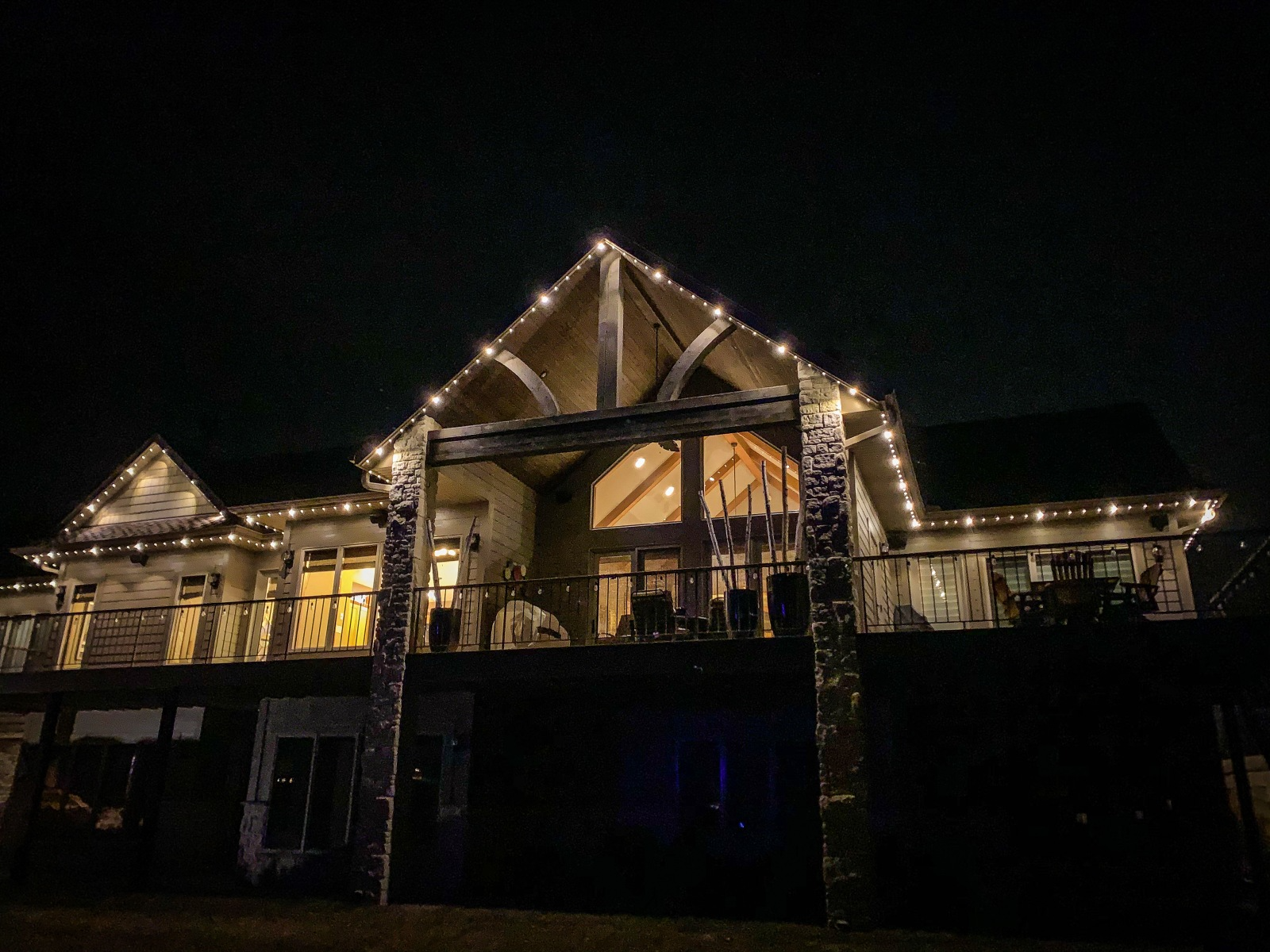 A beautifully lit house glows warmly against a dark night sky