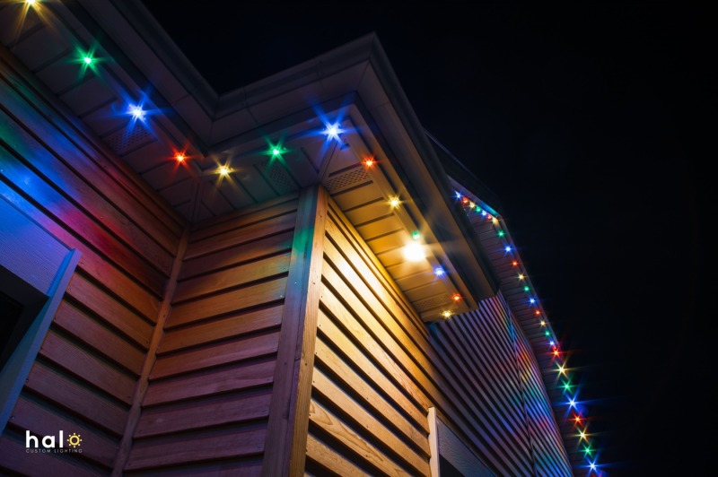Colorful holiday lights illuminate the exterior of a building at night