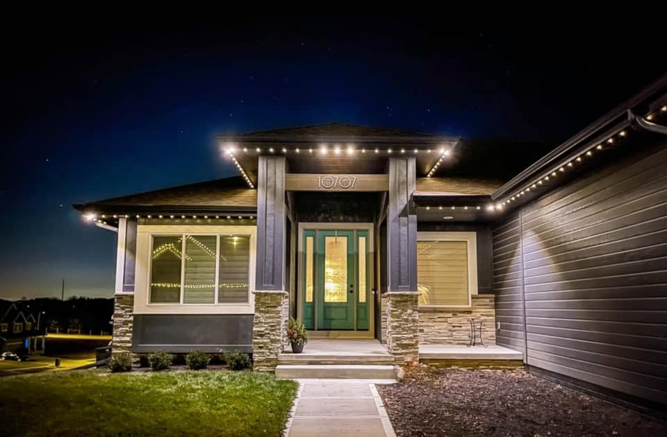 A well-lit front porch showcases a welcoming home under a twilight sky